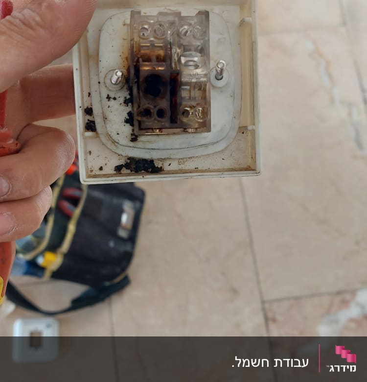 שקע חשמלי מפורק עם סימני שריפה